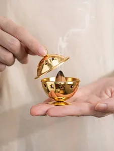 Detail shot of a golden mini metal incense burner with exquisite hollow star moon cutouts.
