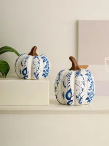 Ceramic blue and white porcelain pumpkin ornament, delicate floral pattern home decor detail.
