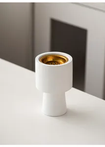 Close-up view of a minimalist white textured aromatherapy incense burner with a gold interior.
