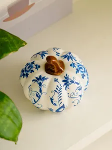 Detailed close-up of a blue and white ceramic pumpkin figurine with delicate floral patterns.