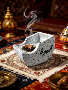 Close-up detail of creative resin bow-shaped incense burner with Arabic calligraphy design.