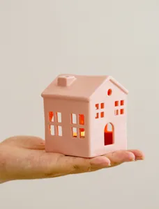 Pink ceramic house candle holder detail, hollow out design, warm glowing home decor.
