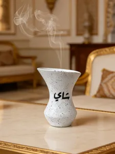 Detailaufnahme eines Harz-Räucherfasses mit arabischem Text und Raucheffekt im Interieur.