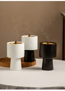 Close-up detail of modern minimal incense burners with golden bowls and rising smoke for home decor.