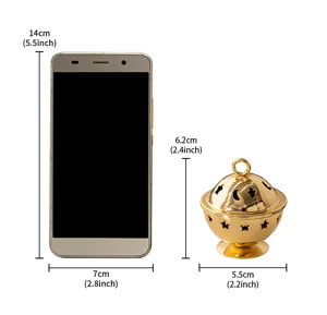 Detail view of mini golden metal incense burner with star moon cutouts, size reference.