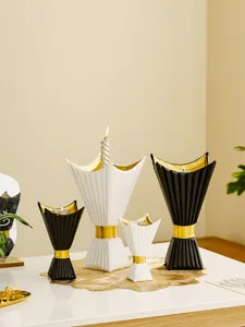 Close-up of elegant black and white candle holders with gold accent for home decor scene.