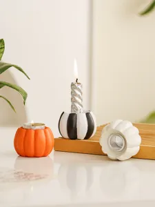 Detailed view of resin pumpkin candle holders for holiday decor, tabletop autumn display.
