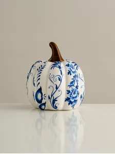 Detailed view of blue and white ceramic pumpkin ornament with delicate floral vine patterns.