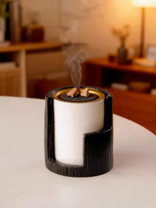 Modern Arabic incense burner detail shot, elegant black and white desktop decor aroma diffuser.