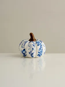 Blue and white ceramic pumpkin figurine with floral pattern and brown stem for decor detail.