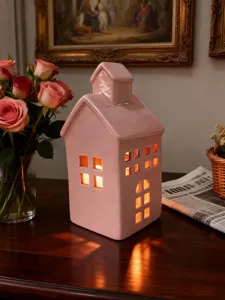 Porte-bougie maison en céramique rose avec fenêtres, lueur chaleureuse pour décoration.