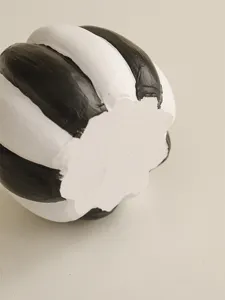 Detailed close-up of a resin black and white striped pumpkin decor, perfect for Halloween styling.