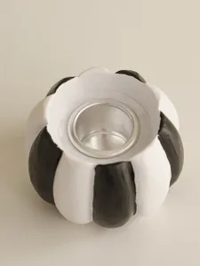 Detail shot of black and white striped resin pumpkin candle holder showing texture and metal insert.