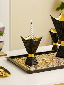 Detailed close-up view of the elegant black and gold candle holder on a decorative tray.
