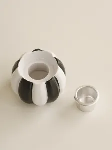 Resin pumpkin candle holder detail view, black and white striped seasonal holiday decor.