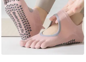 Close-up view of pink five toe yoga socks detail, anti-slip grip sole for pilates and fitness.