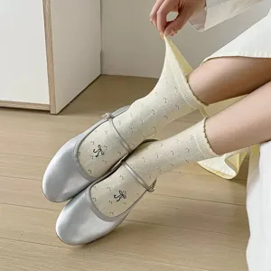 Cream floral hollow out ballet style bow solid color jacquard casual mid tube socks.