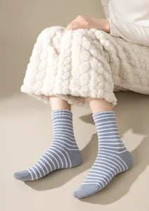 Detail view of comfortable striped mid-calf cotton socks worn in a cozy daily setting.