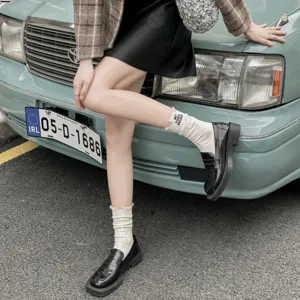 Detailed shot of women's trendy embroidered slouch socks with distressed design for autumn.