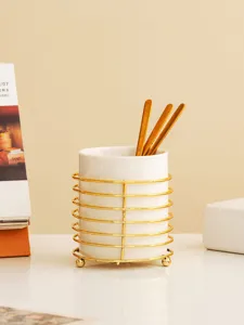 Detail view of white ceramic tableware storage holder with elegant gold metal wire frame.