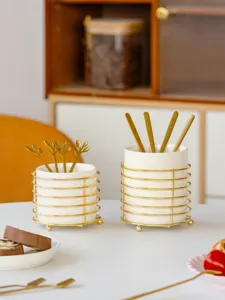 Close-up view of minimalist ceramic tableware storage holders with gold wire frame.