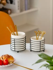 Ceramic tableware storage jar with metal wire holder and golden spoons for desktop organization