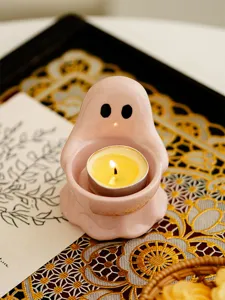 Pink ceramic ghost tealight candle holder detail shot, cute home decor table ornament aesthetic.