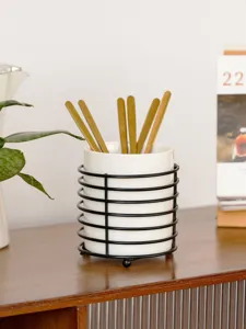 White ceramic chopstick holder with black metal wire frame for desktop kitchen tableware storage.