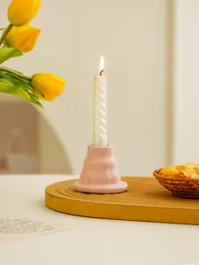 Minimalist pink ceramic candle holder with spiral white candle for cozy home decor and tabletop.