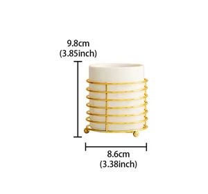 White ceramic cutlery holder detail with gold metal rack showcasing compact desktop storage.