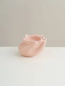 Detailed close-up of pink ceramic hand-shaped candle holder, ideal for modern tabletop decor.