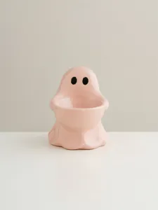 Pink ceramic ghost detail view, cute ghost shape candle holder, home desktop decor piece.
