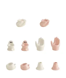 Detailed view of cute ceramic candle holders in various creative shapes like ghost and hand.