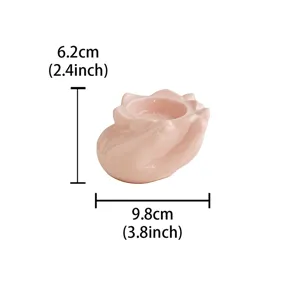 Pink ceramic hand-shaped candle holder, creative lotus design for home decor and tabletop.