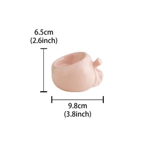 Detail view of the cute pink peach ceramic candle holder, showing compact size and fine glaze finish.