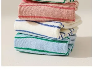 Close-up detail view of colorful striped knitted socks stacked neatly in soft pastel tones.