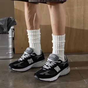 Close-up of white ribbed pile socks paired with vintage sneakers, showcasing cityboy fashion.