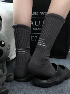 Close-up of dark grey ribbed athletic socks with English print and cozy towel bottom.