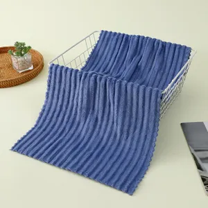 Vue détaillée de la serviette côtelée en polaire corail bleue, tissu absorbant doux pour bain.