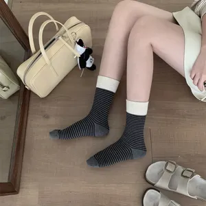 Close-up detail of women's contrast ribbed striped mid-tube socks worn on legs, casual style.