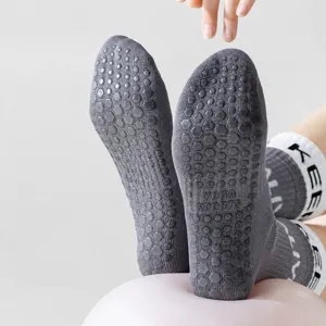 Calzini da yoga antiscivolo grigi con pallini in silicone sulla suola per fitness e pilates.