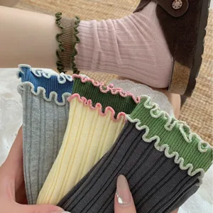 Close-up detail of contrast color lettuce edge mid-tube socks with cute wavy ribbed cuffs.