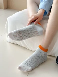 Detailed view of women summer mesh socks, breathable hollow-out design with orange color-block cuff.