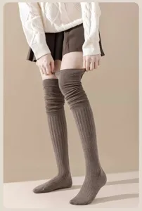 Detail shot showing the texture and length of brown over-the-knee slouchy knit socks.