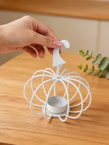Close-up of white iron pumpkin candle holder, perfect for tabletop decor and cozy home styling.