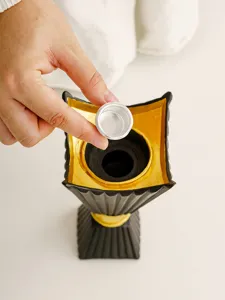 Detail view of black and gold Middle Eastern style candle holder with metal cup.