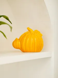 Ceramic yellow pumpkin decoration close up, modern minimalist desktop art ornament for home decor.