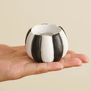 Black and white striped pumpkin candle holder, resin material for Halloween home decor.