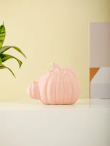Pink ceramic pumpkin figurine for modern desktop decor, cute autumn home ornament display.