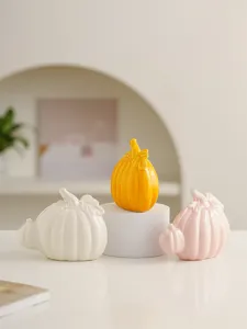 Close-up detail of modern ceramic pumpkin decorative ornaments for desktop and living room.
